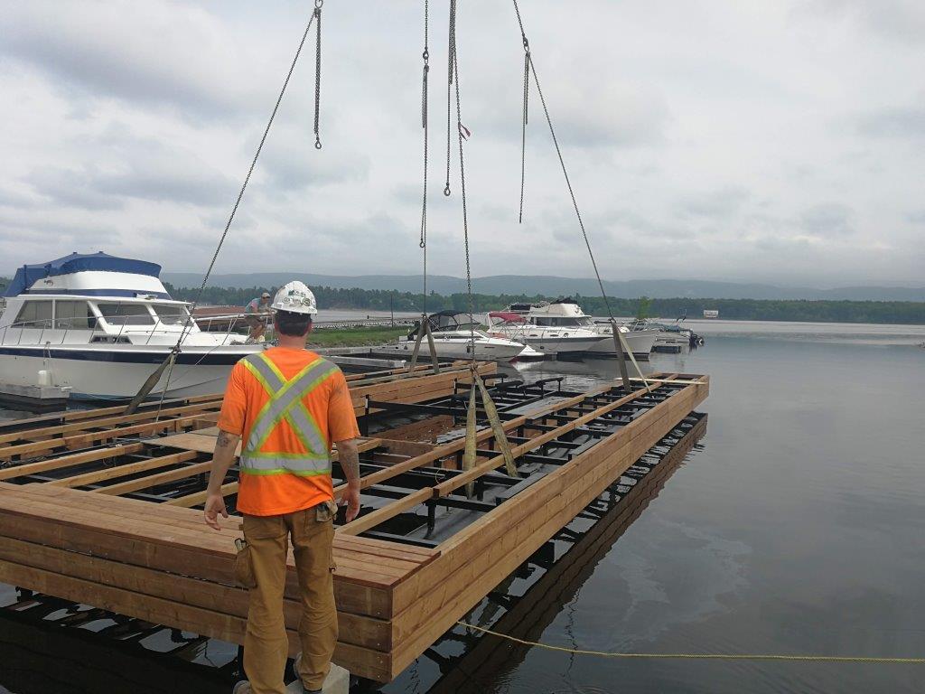 Crane lifting custom dock into harbor